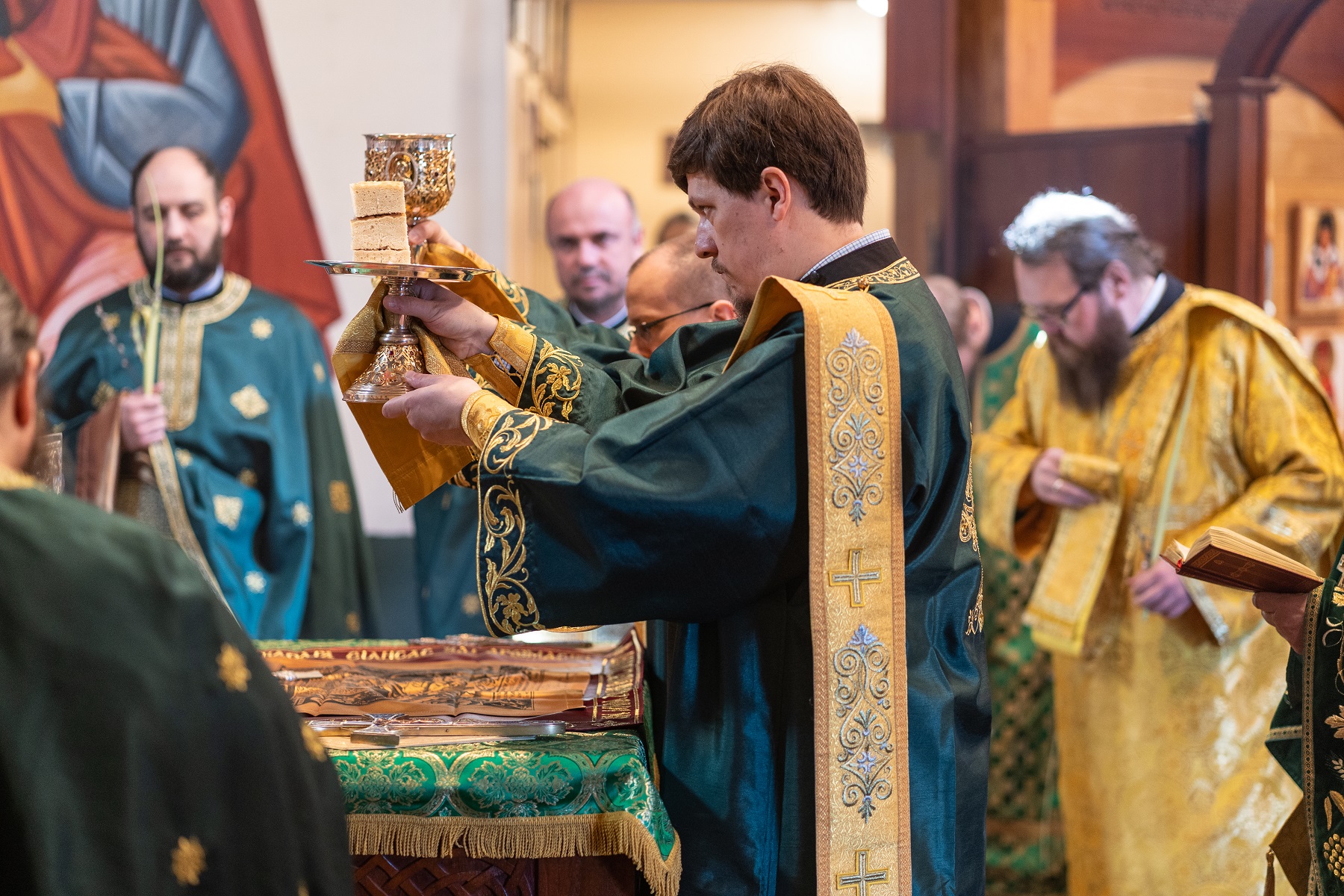 Dns Vitaly Permiakov and John Black elevate the paten and chalice during Palm Sunday liturgy