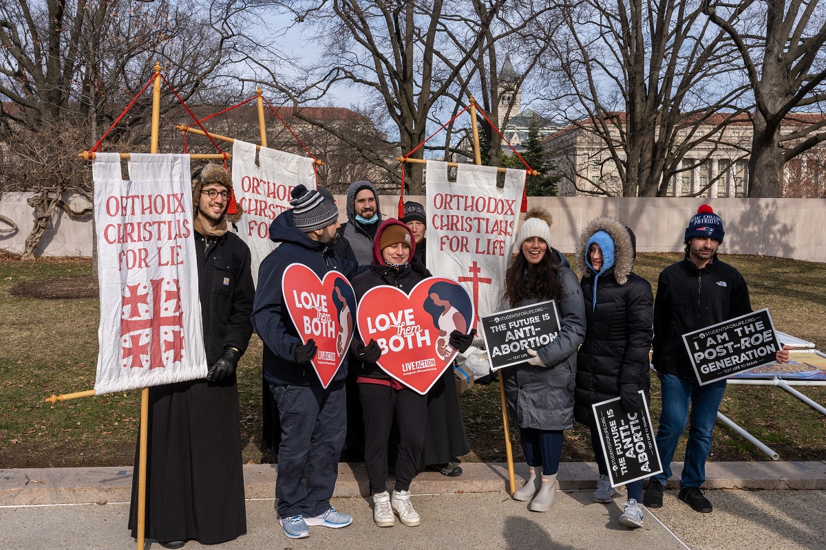 Seminarians hold up signs