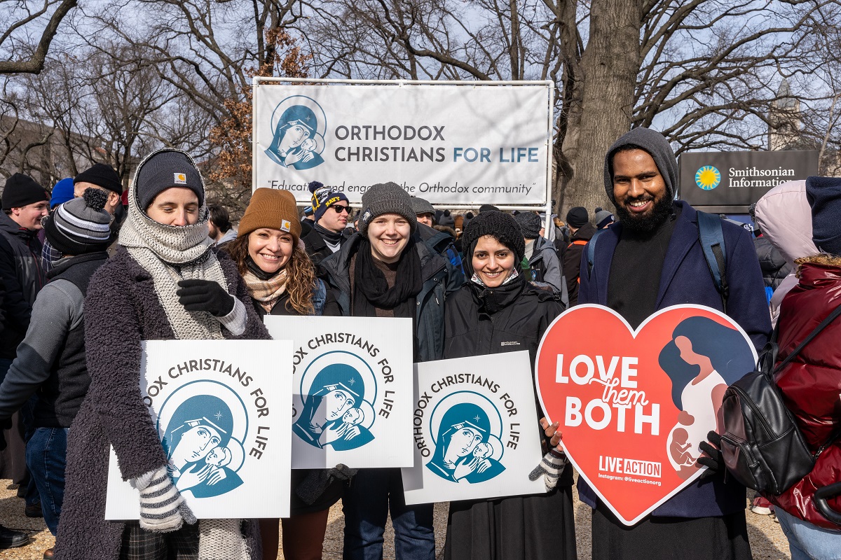 Seminarians smiles and hold up signs