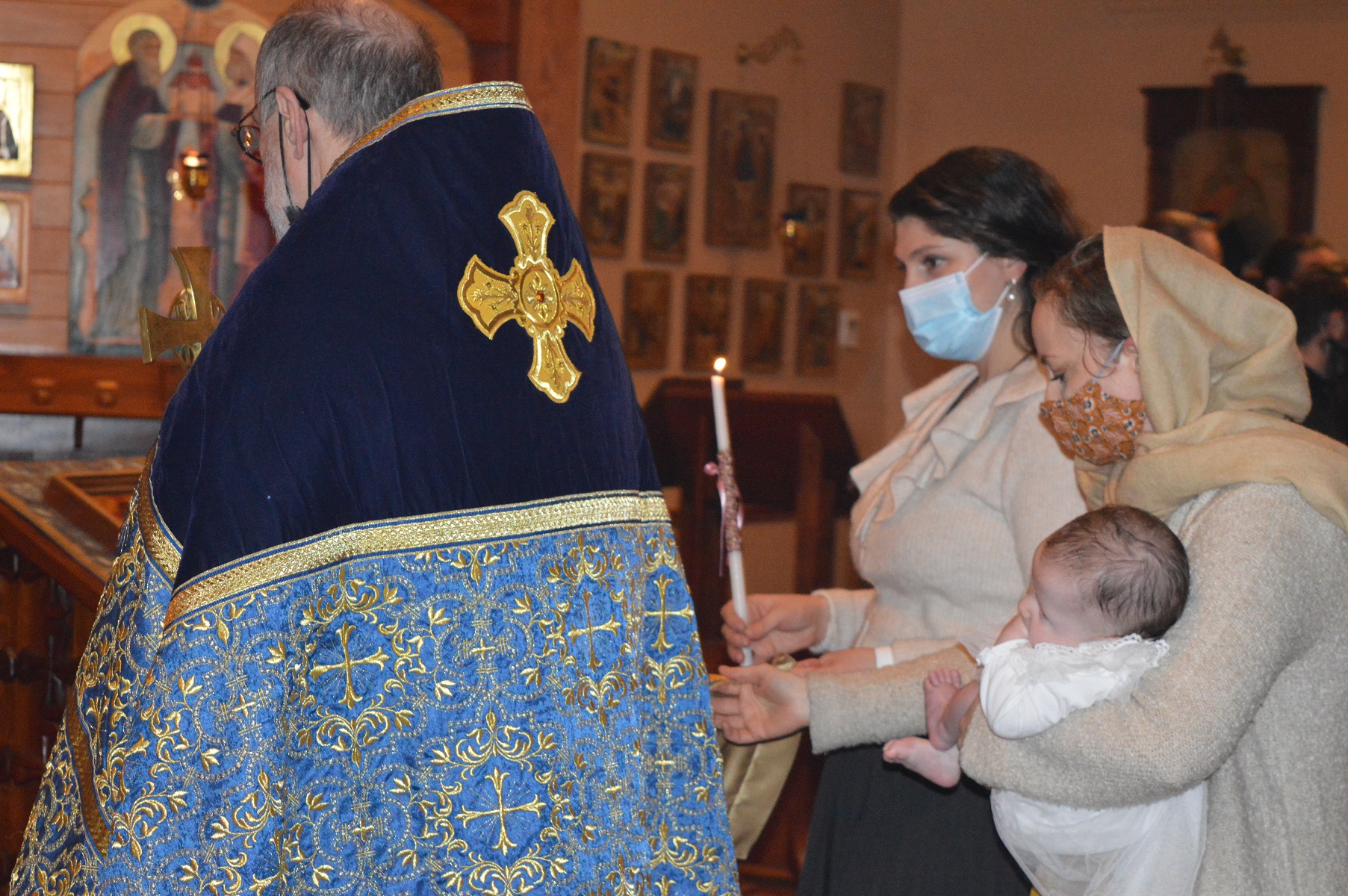 Fr Chad prays as baby Eugenia is held behind him