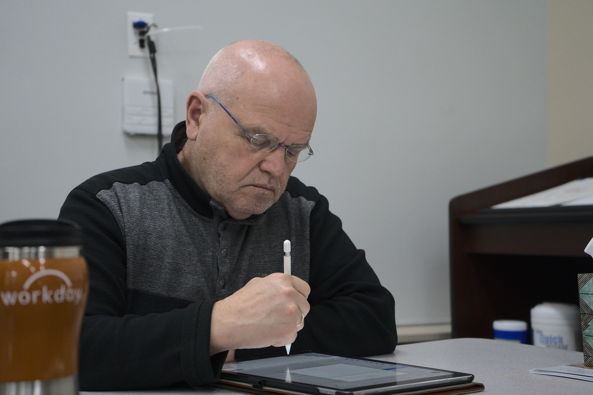 Dr Kordis works on his tablet as students complete their projects