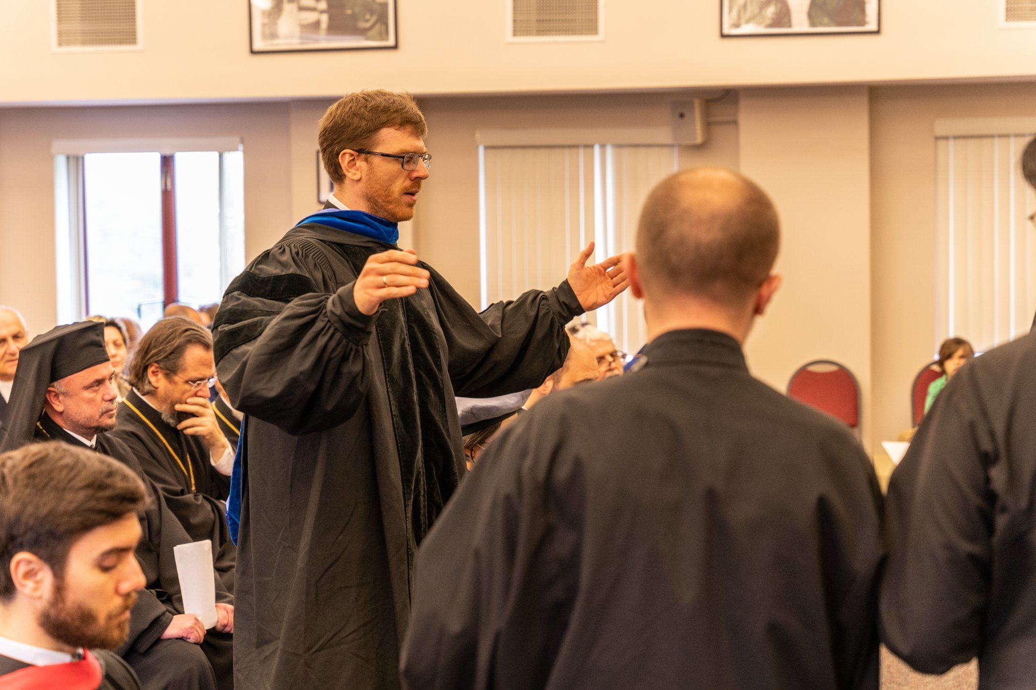 Dr Harrison Russin conducts a choral performance during commencement