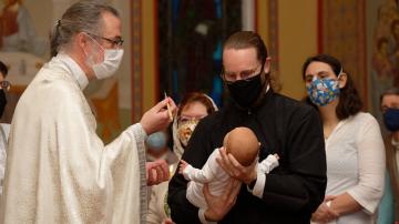 Fr Theophan prepares to anoint the child with Holy Chrism