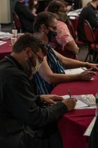 Participants take notes during a conference session