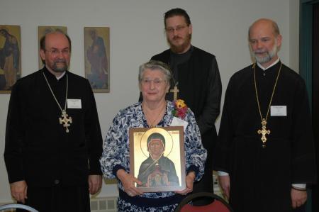 Ann Zinzel receiving an icon of her patron, the Prophetess Anna, at the Alumni Association banquet (from left) Chancellor/CEO Fr. Chad Hatfield, Dean Fr. John Behr, and then Alumni Association President Fr. David Barr