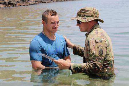 The soldier smiles as Fr James continues the baptism in the Gulf of Aden