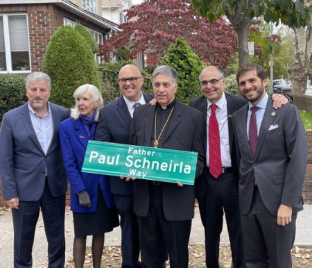 Fr Michael Ellias holds the new street sign bearing Fr Paul's name