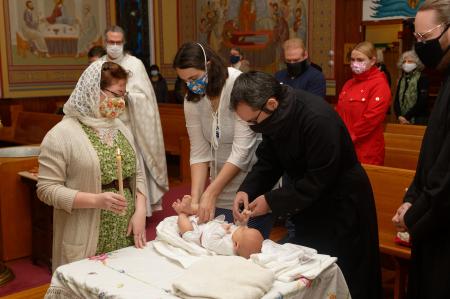 Paul and Sarah change Luca into his baptismal robe