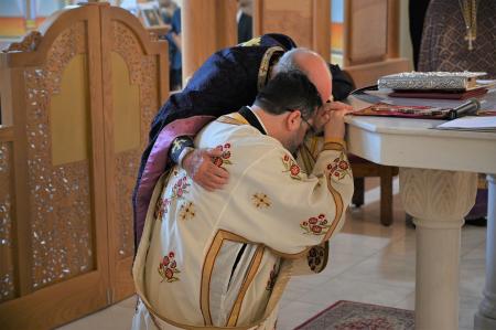 Priest candidate kneels at the altar during his ordination