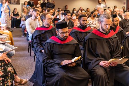 Members of the diverse graduating class sit together at the ceremony